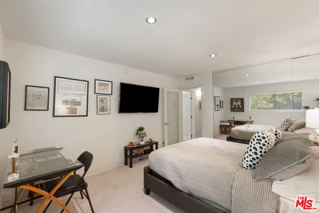 a bedroom with a bed and a flat screen tv