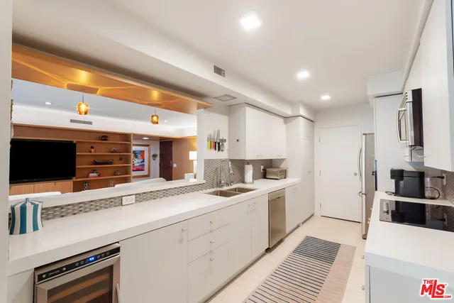 a kitchen with stainless steel appliances kitchen island granite countertop a sink and cabinets