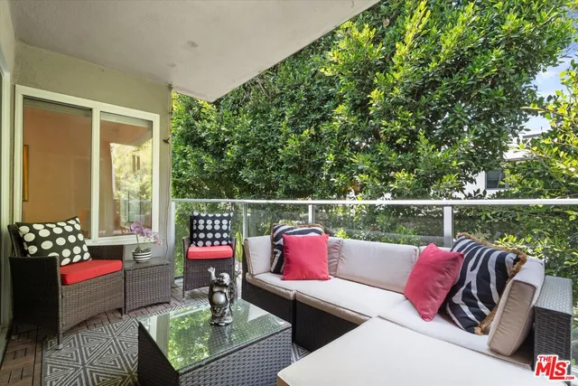 a balcony with wooden floor and outdoor seating
