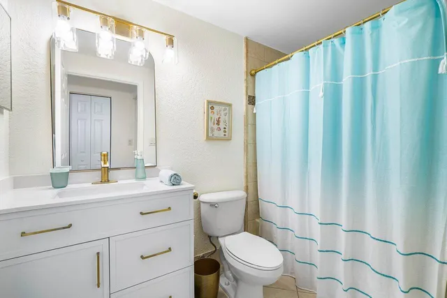 a bathroom with a toilet a sink and a mirror