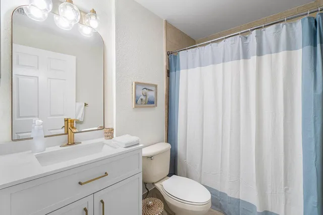 a bathroom with a sink a toilet and shower curtain