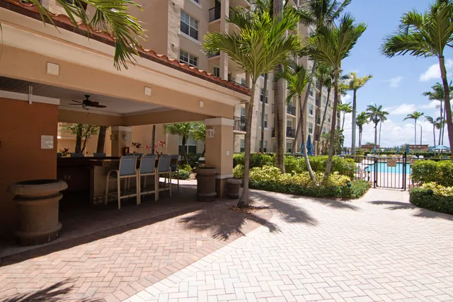 a view of a patio with table and chairs potted plants and palm trees