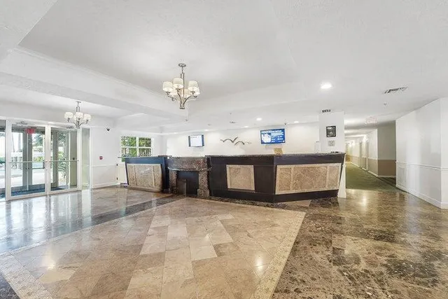 a view of a kitchen with a sink stainless steel appliances cabinets and living room view