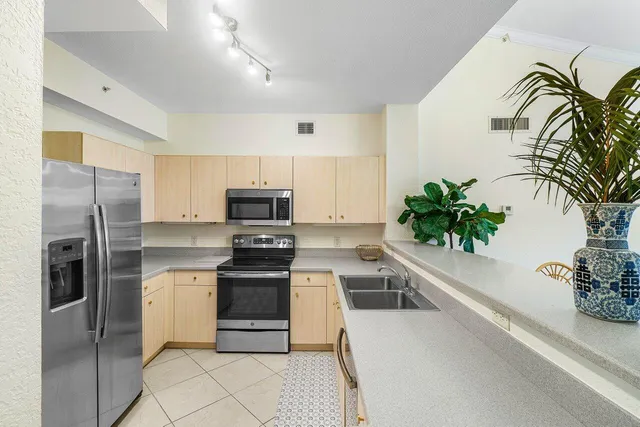a kitchen with stainless steel appliances a sink a microwave a stove and cabinets