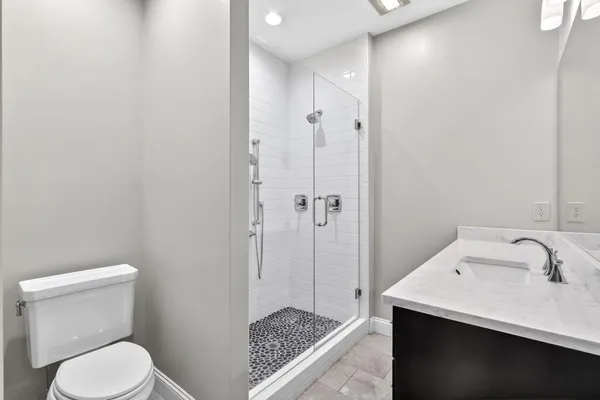 a bathroom with a sink a toilet and shower