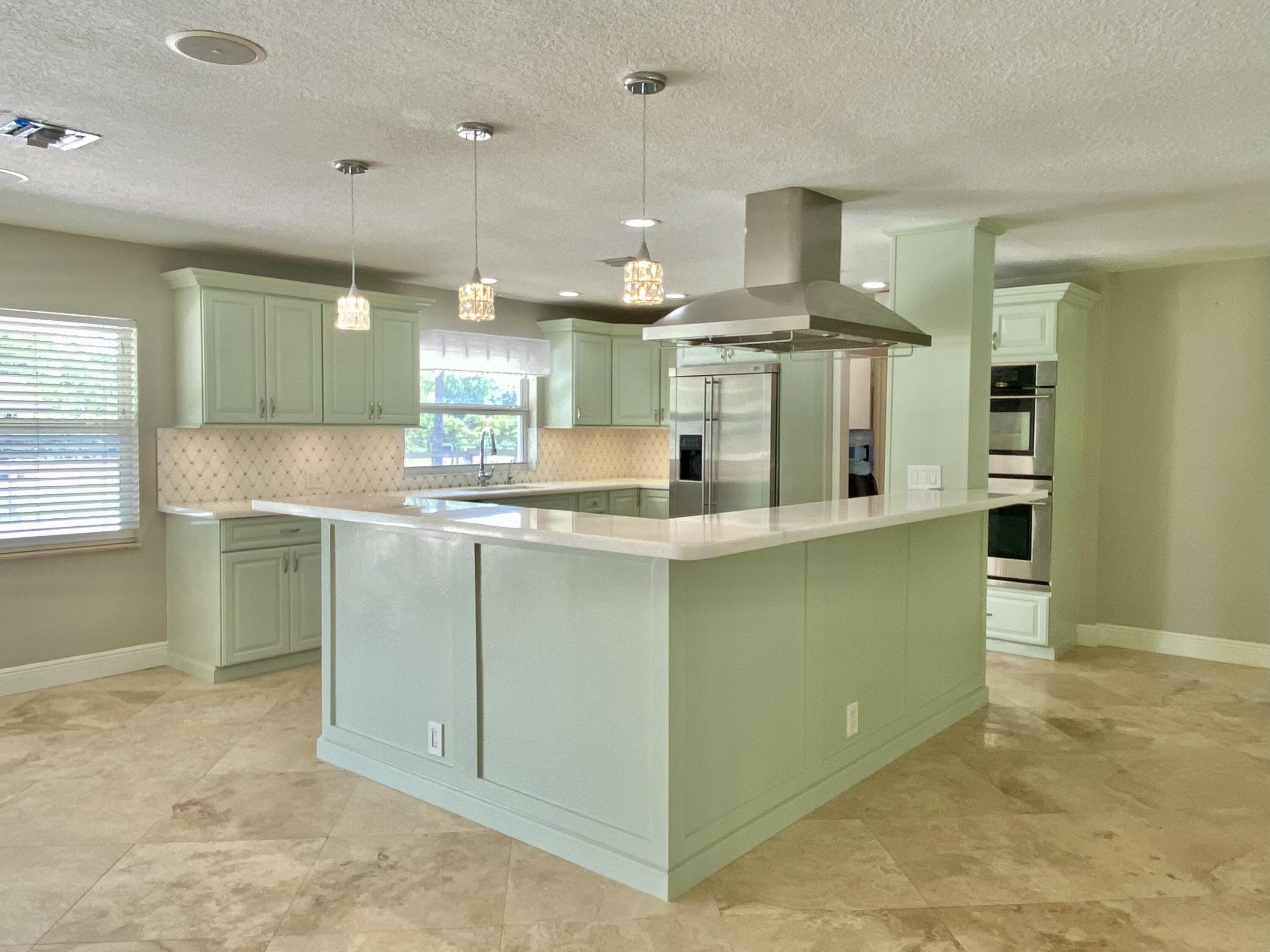 16605 115th Avenue North Jupiter, FL 33478 - Photo 11 of 54 a kitchen with kitchen island a sink stainless steel appliances and cabinets