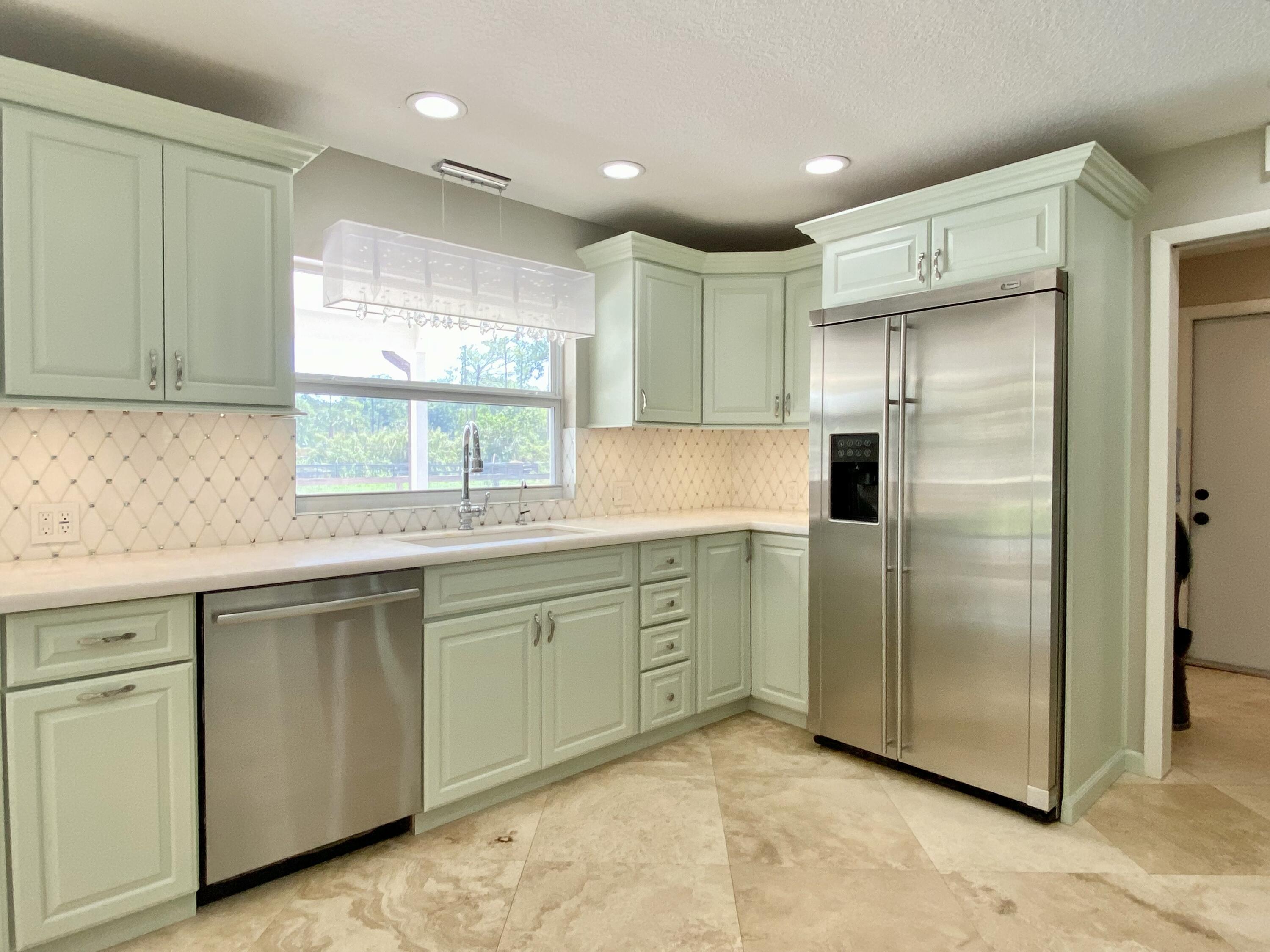 16605 115th Avenue North Jupiter, FL 33478 - Photo 14 of 54 a kitchen with stainless steel appliances granite countertop a refrigerator and a sink