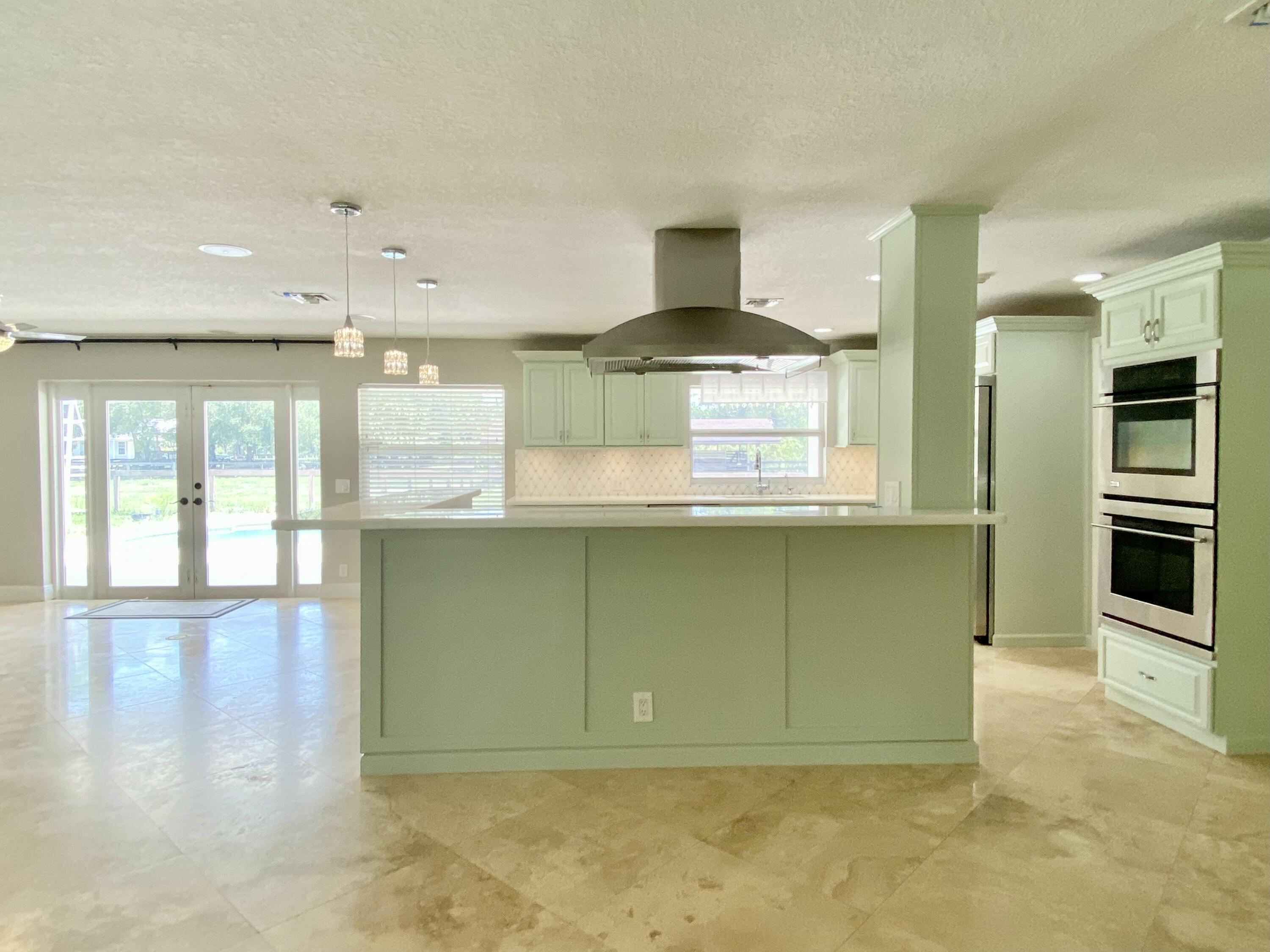 16605 115th Avenue North Jupiter, FL 33478 - Photo 16 of 54 a kitchen with stainless steel appliances granite countertop a stove a sink and a refrigerator