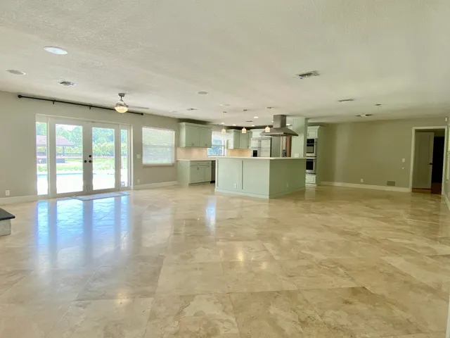 an empty room with a fireplace and a ceiling fan