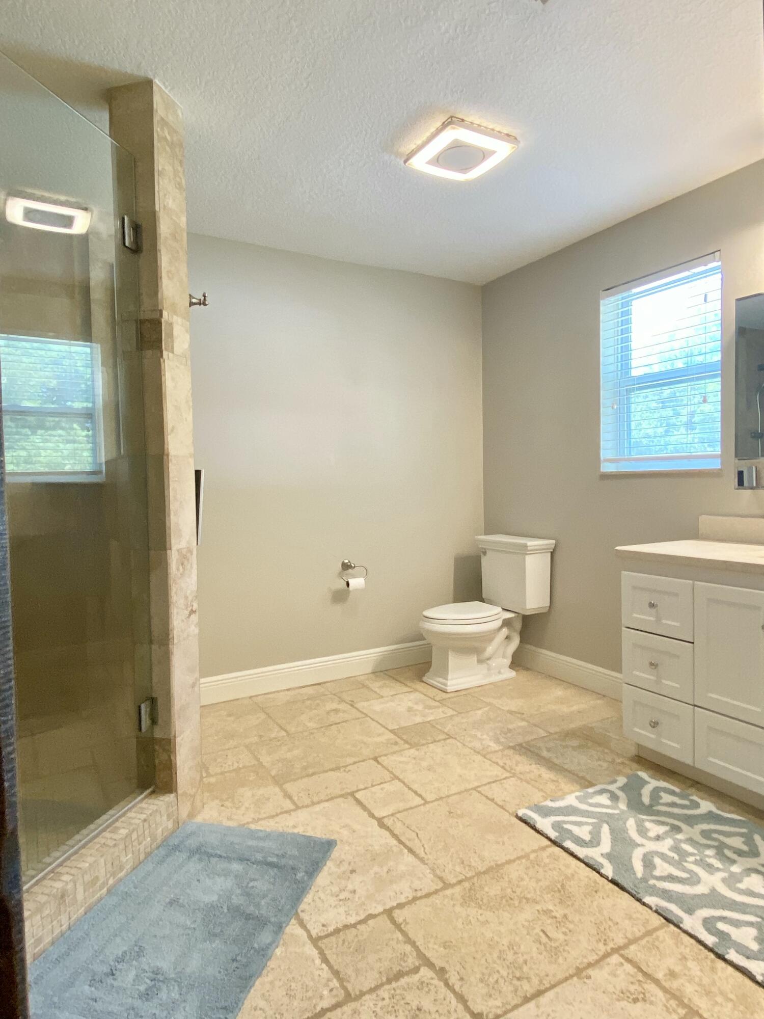 16605 115th Avenue North Jupiter, FL 33478 - Photo 24 of 54 a bathroom with a sink a toilet and shower