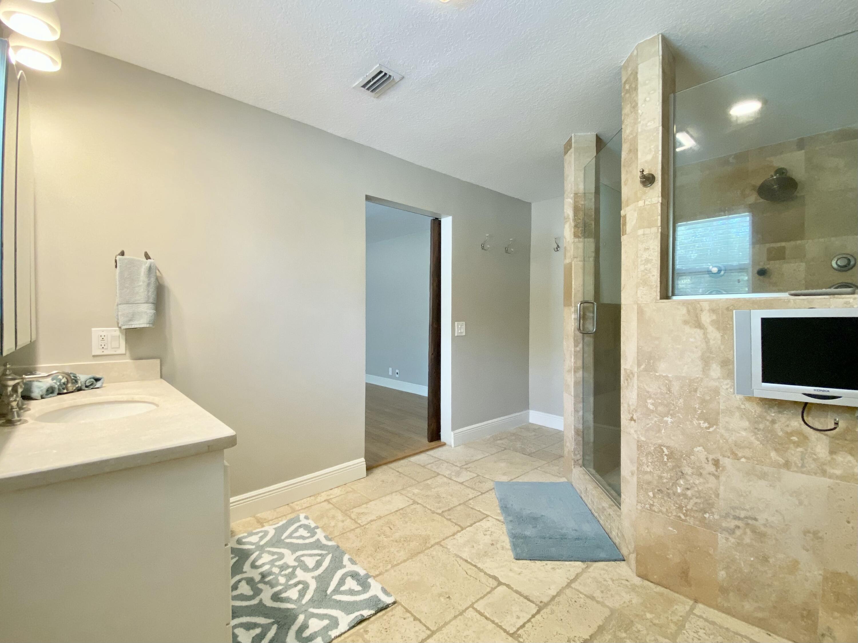 16605 115th Avenue North Jupiter, FL 33478 - Photo 25 of 54 a bathroom with a sink a mirror and a shower