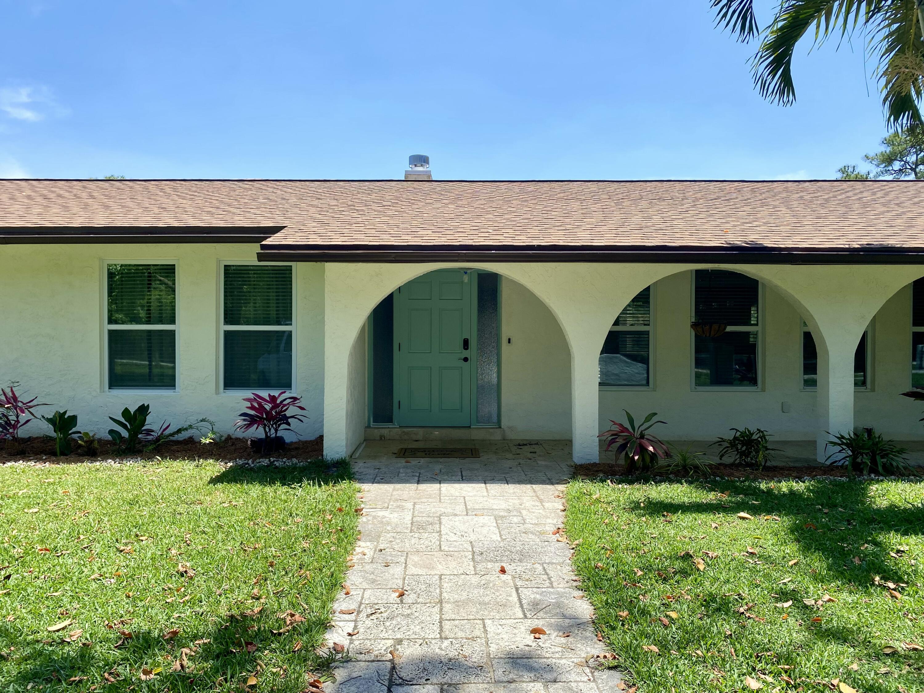16605 115th Avenue North Jupiter, FL 33478 - Photo 3 of 54 a front view of a house with garden