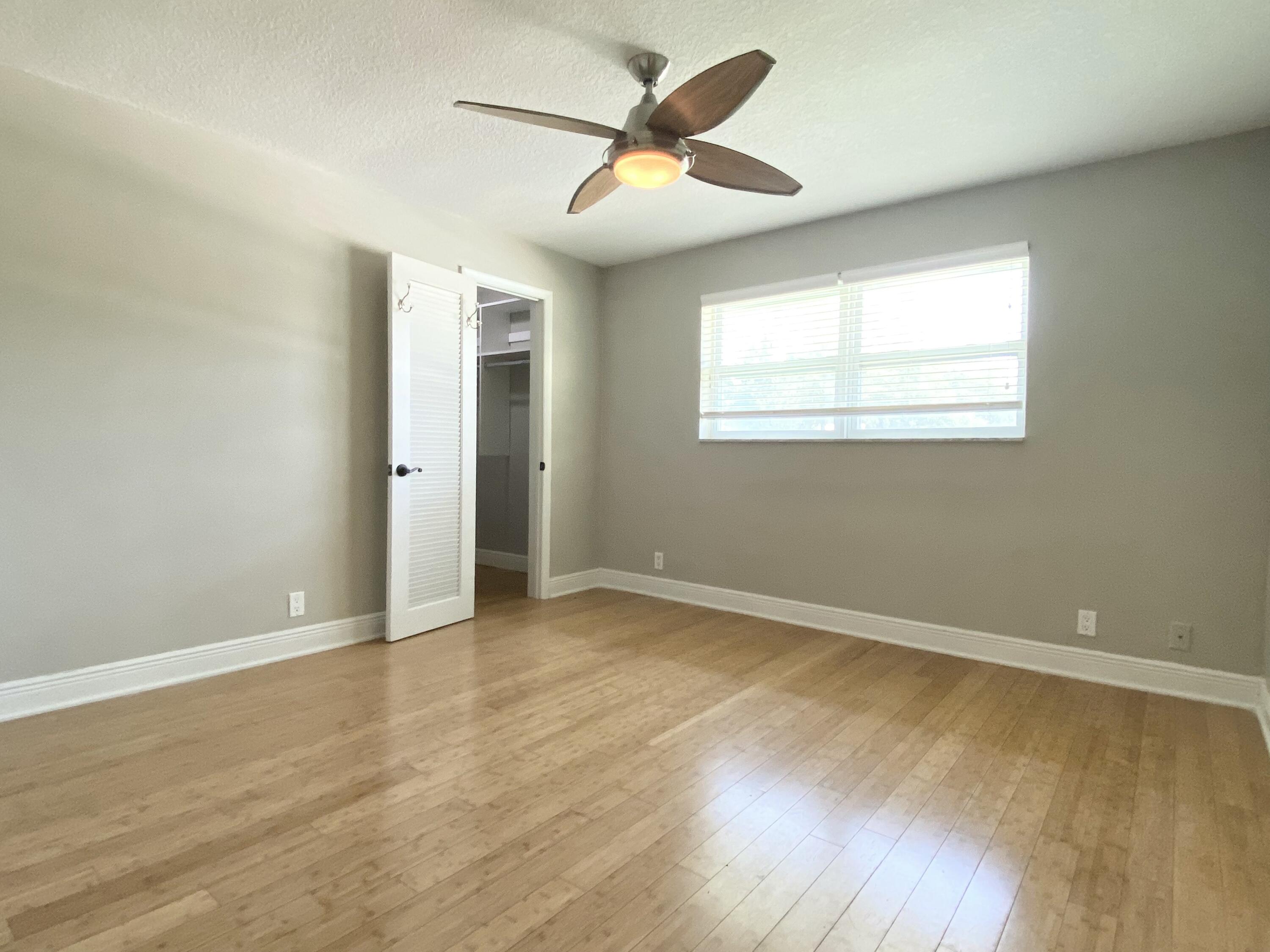 16605 115th Avenue North Jupiter, FL 33478 - Photo 31 of 54 an empty room with wooden floor and windows