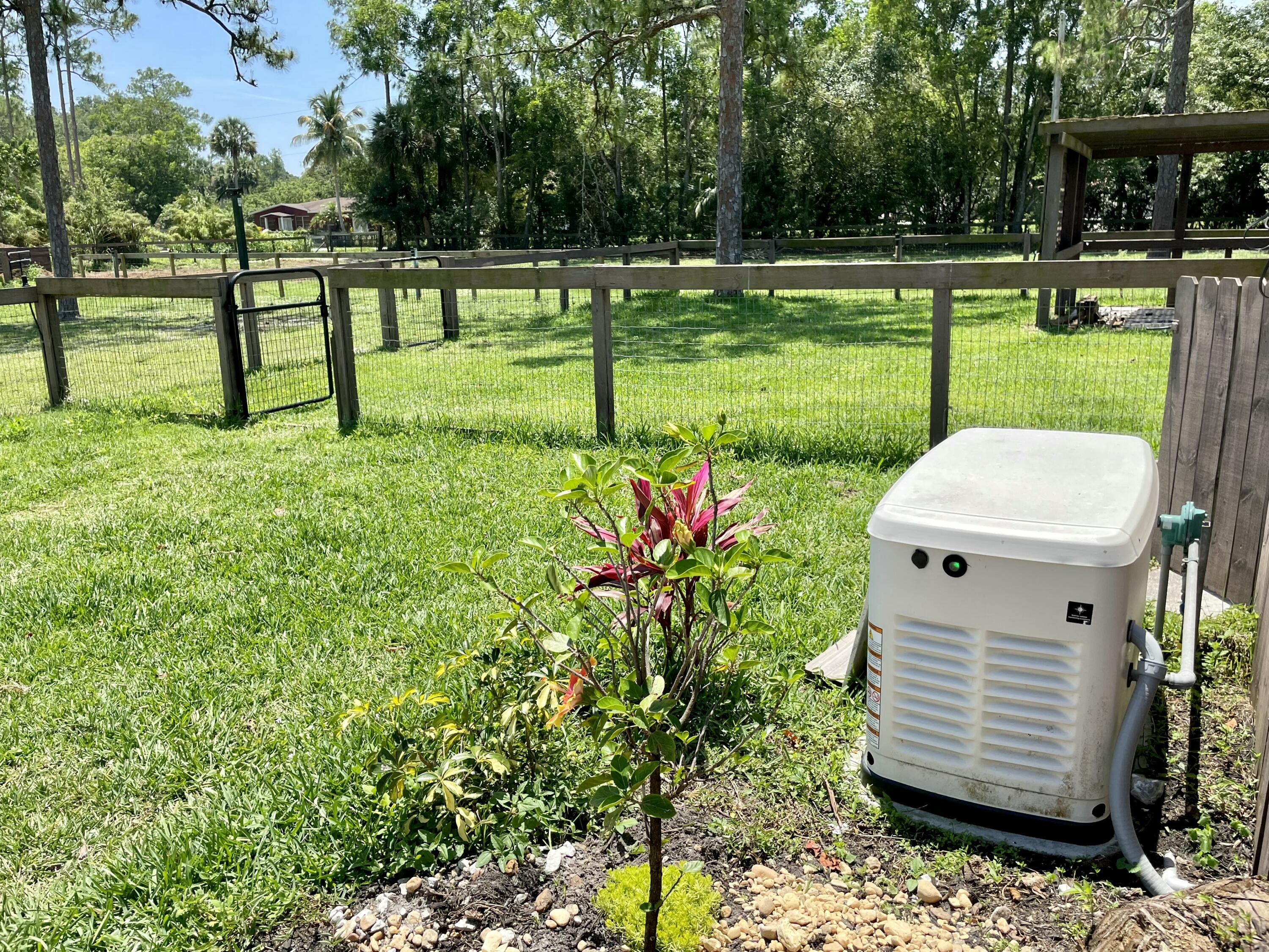 16605 115th Avenue North Jupiter, FL 33478 - Photo 41 of 54 a view of a white house with a yard and sitting area