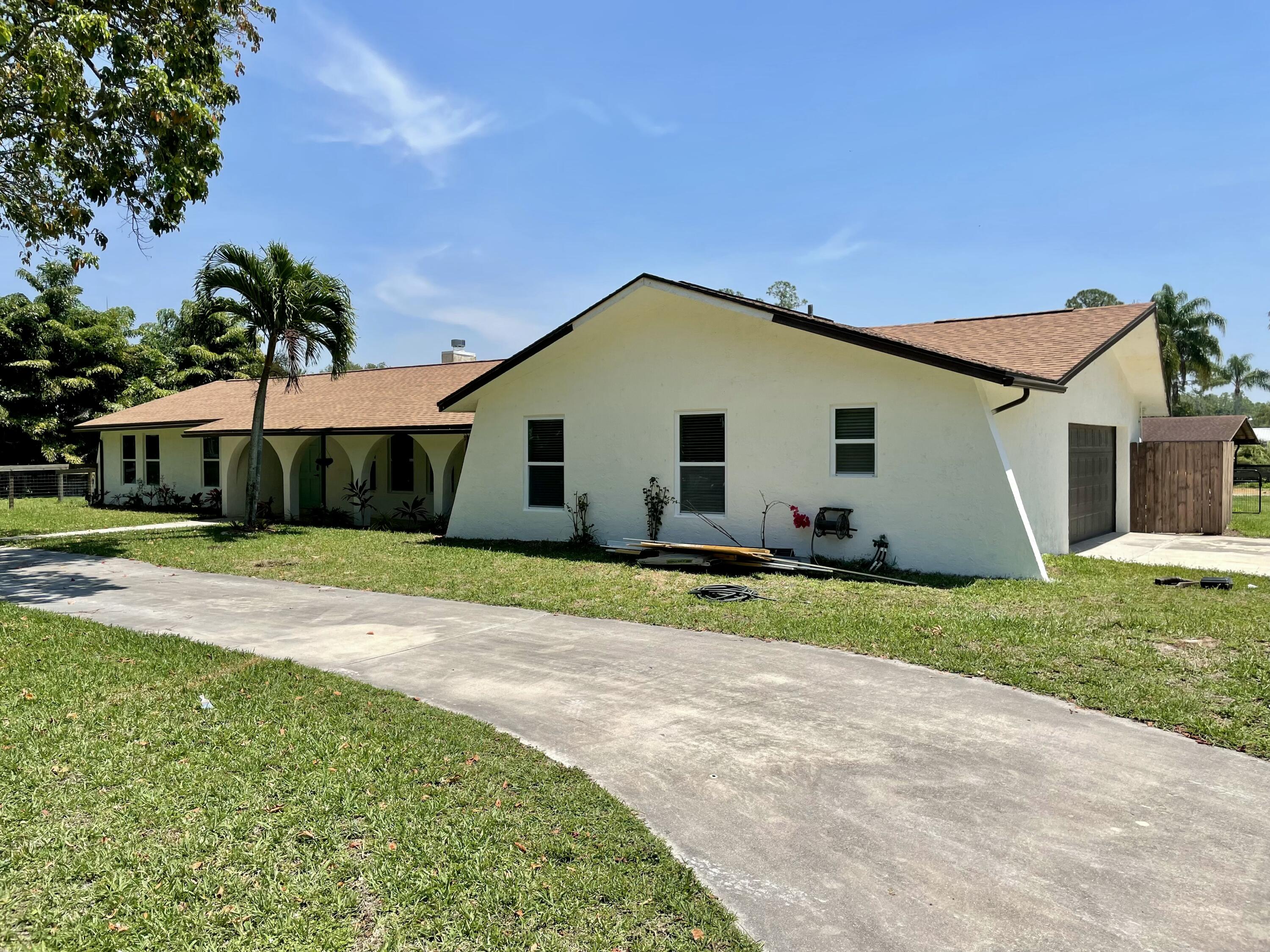 16605 115th Avenue North Jupiter, FL 33478 - Photo 7 of 54 a front view of a house with a yard