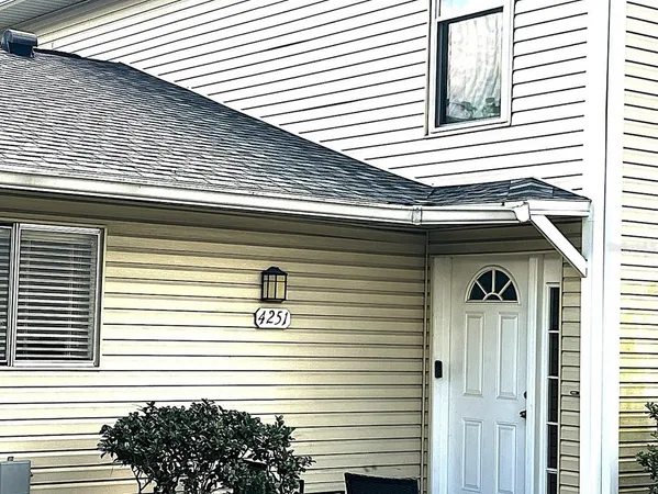 a view of a house with a door and a large tree