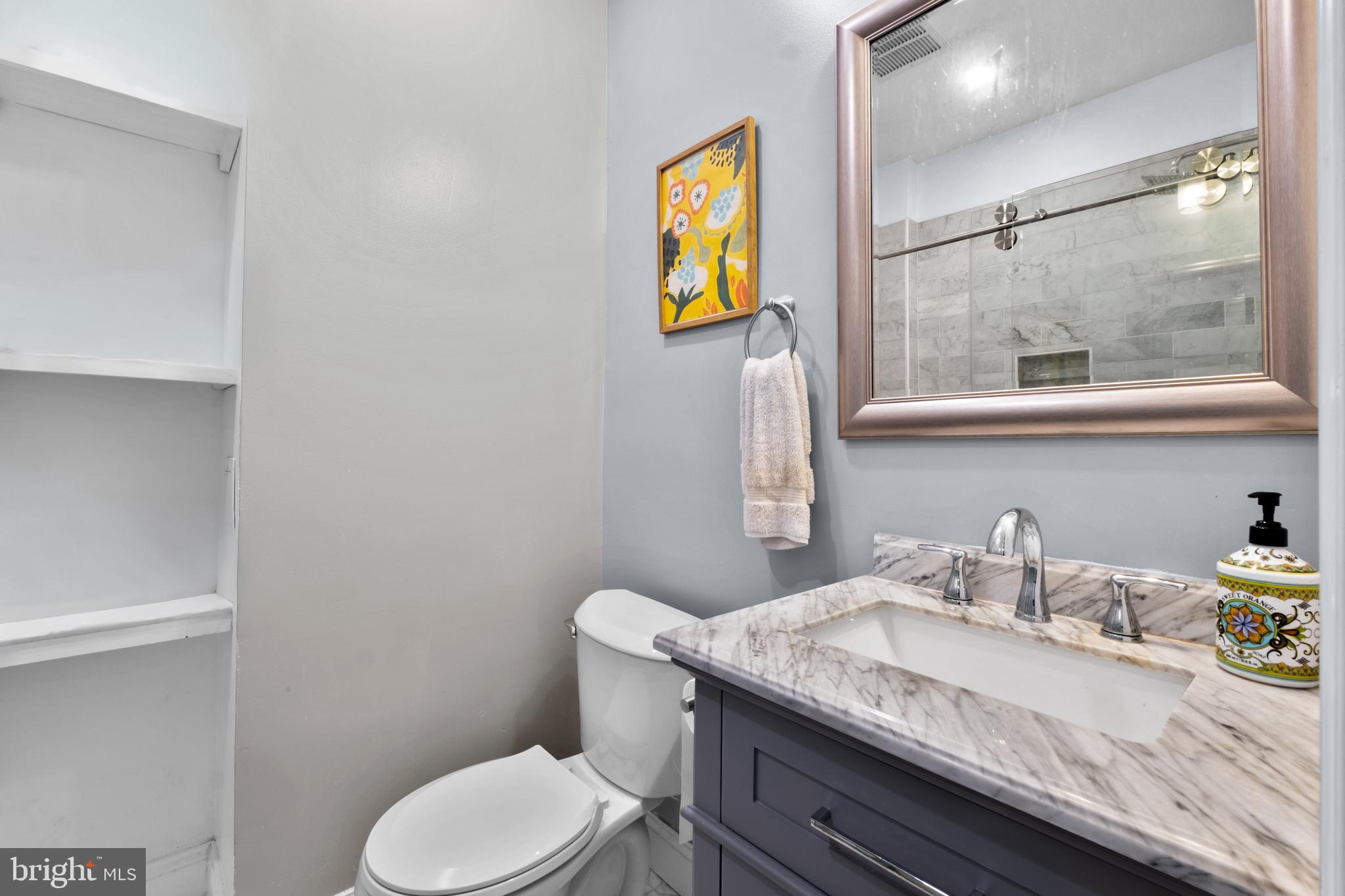 1121 Walnut Street Philadelphia, PA 19107 - Photo 27 of 38 a bathroom with a granite countertop toilet sink and mirror