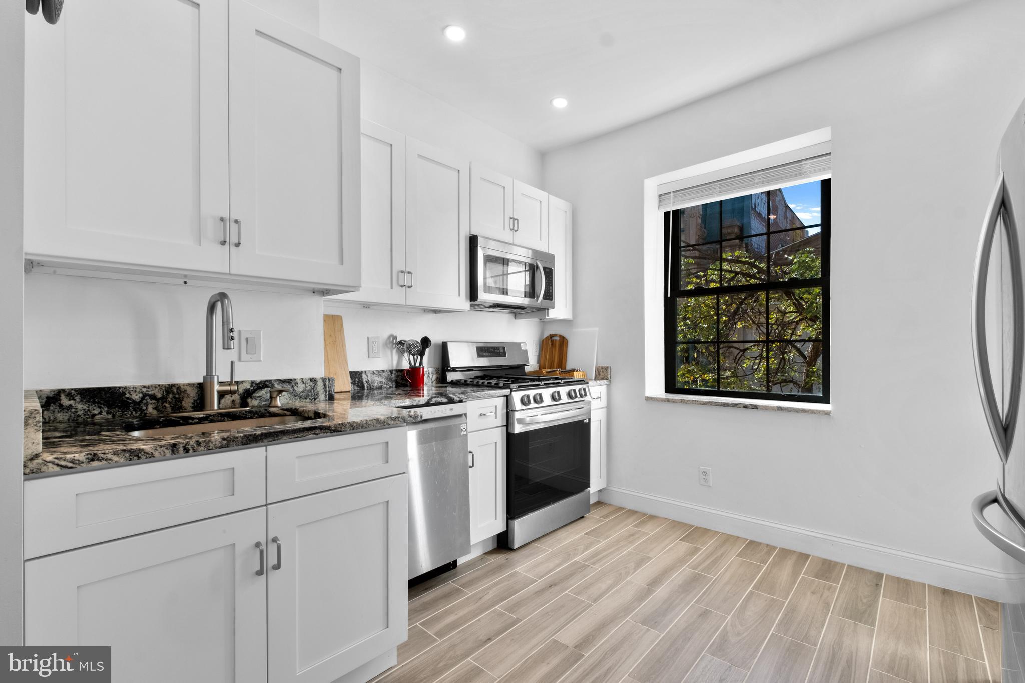 1121 Walnut Street Philadelphia, PA 19107 - Photo 29 of 38 a kitchen with stainless steel appliances granite countertop white cabinets stove a sink and dishwasher