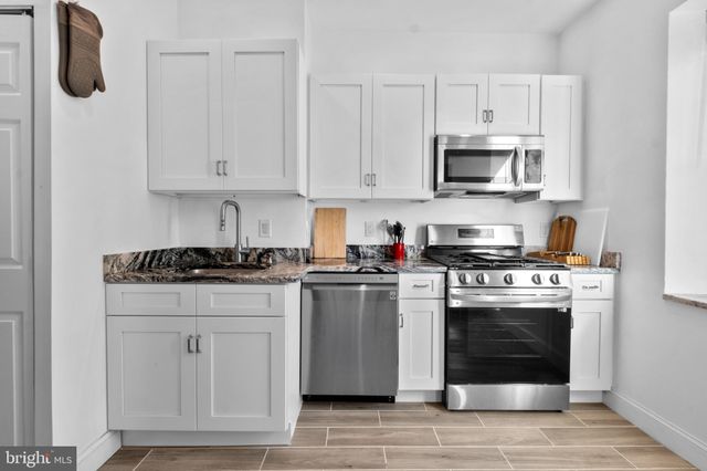 a kitchen with stainless steel appliances granite countertop a refrigerator stove and sink