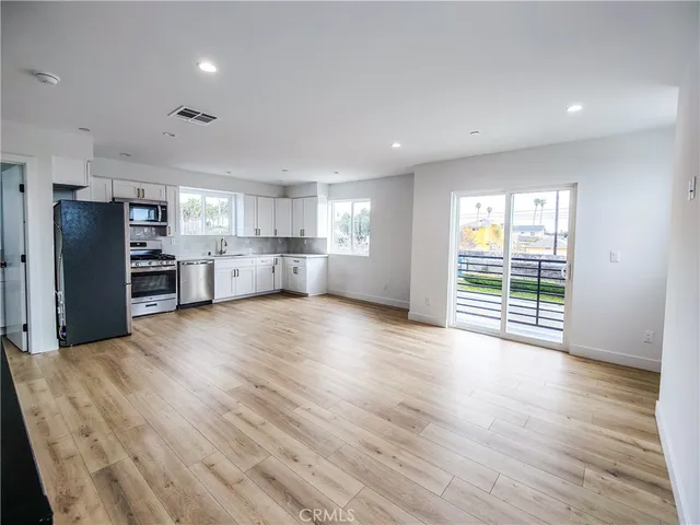 a view of kitchen with wooden floor and electronic appliances