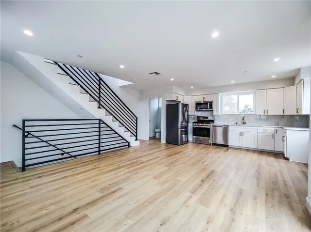 a kitchen with stainless steel appliances granite countertop a refrigerator sink and stove
