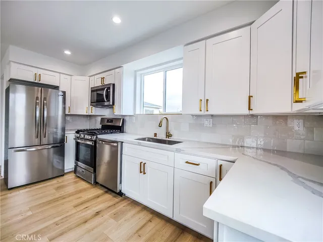 a kitchen with stainless steel appliances a refrigerator sink and microwave