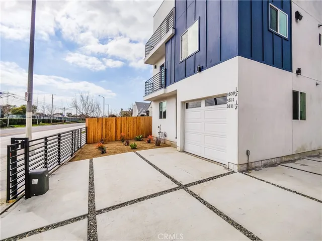 a living room with furniture kitchen view and a wooden floor