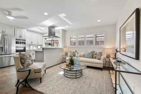 a living room with stainless steel appliances furniture and a large window