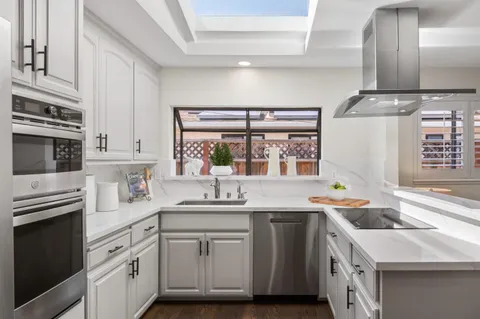 a kitchen with stainless steel appliances a sink stove and cabinets