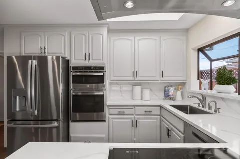 a kitchen with granite countertop a refrigerator sink and stove