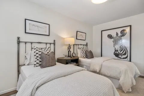 a bedroom with two beds and two windows