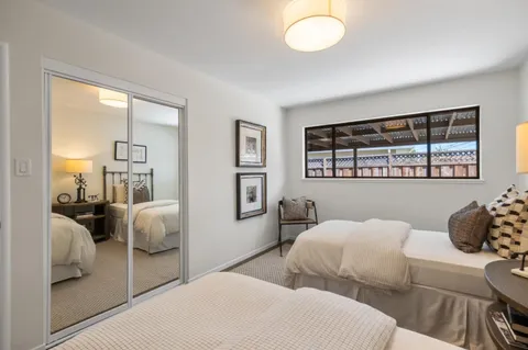 a bedroom with two beds and a large window