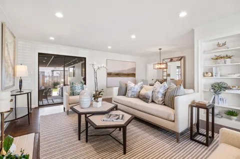 a living room with furniture a wooden floor and next to a window
