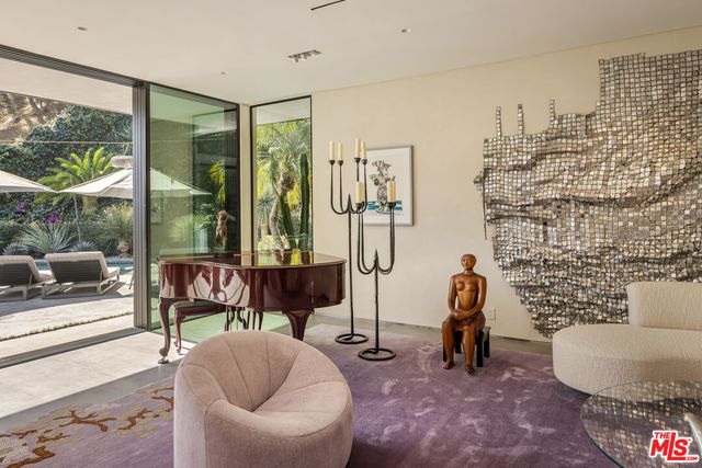 a living room with furniture and a floor to ceiling window