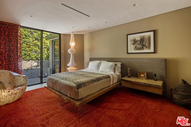 a bedroom with a bed painting and wooden floor