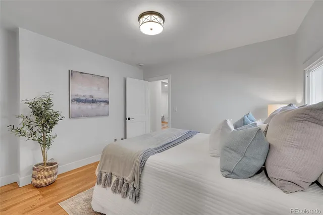 a bedroom with a bed and a potted plant