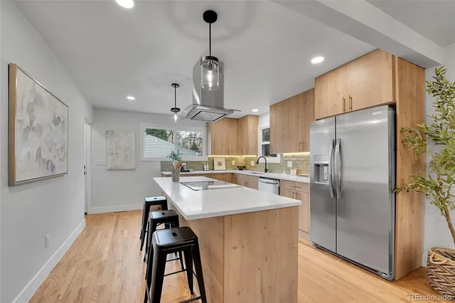 a kitchen with stainless steel appliances kitchen island a refrigerator and a stove top oven