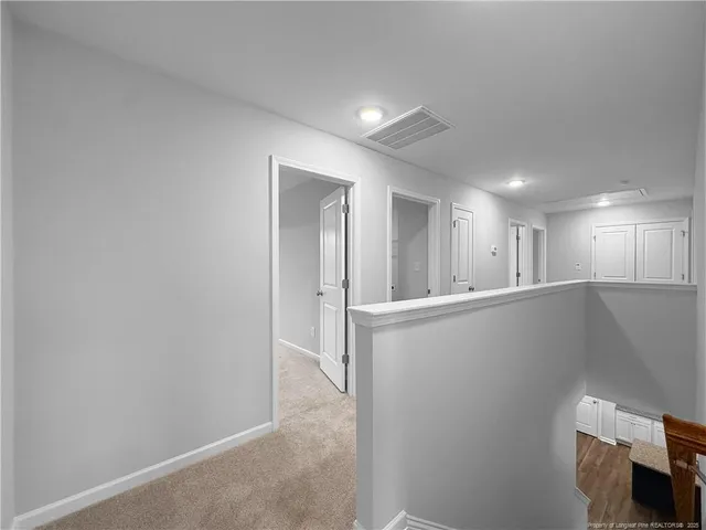 a view of a hallway with white walls and closet