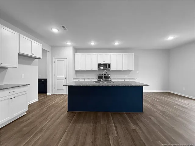 a kitchen with stainless steel appliances granite countertop a stove a sink and a refrigerator