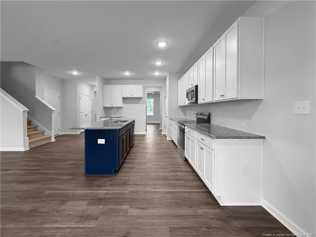 a large kitchen with stainless steel appliances granite countertop a large counter top and a stove top oven