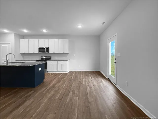 a kitchen with stainless steel appliances granite countertop a sink a stove and a refrigerator