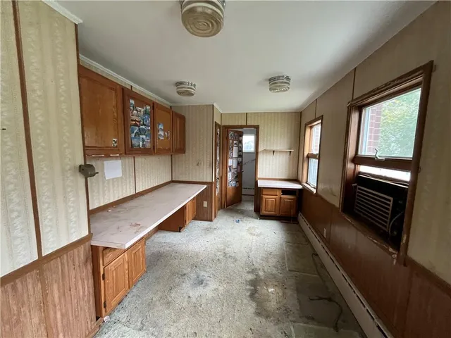 a living room with stainless steel appliances furniture a kitchen view and a large window