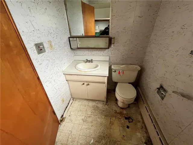 a bathroom with a toilet a sink and mirror