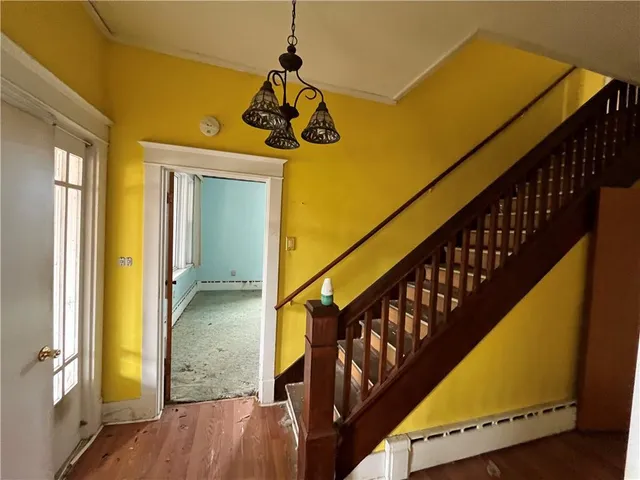 a view of a hallway with wooden floor and staircase