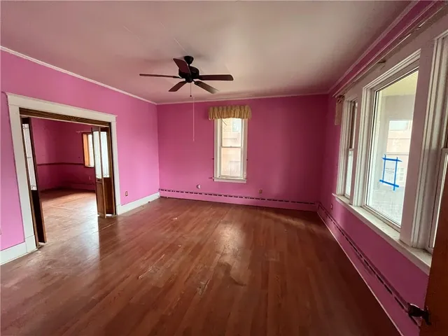 a view of an empty room window and wooden floor