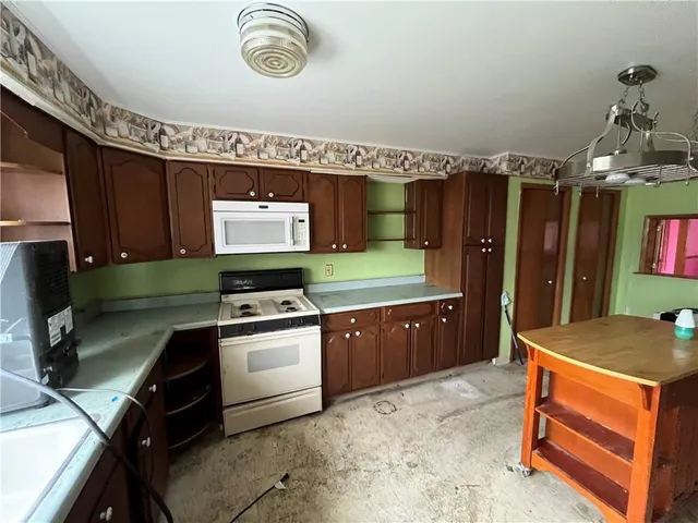 a kitchen with a refrigerator and a stove top oven