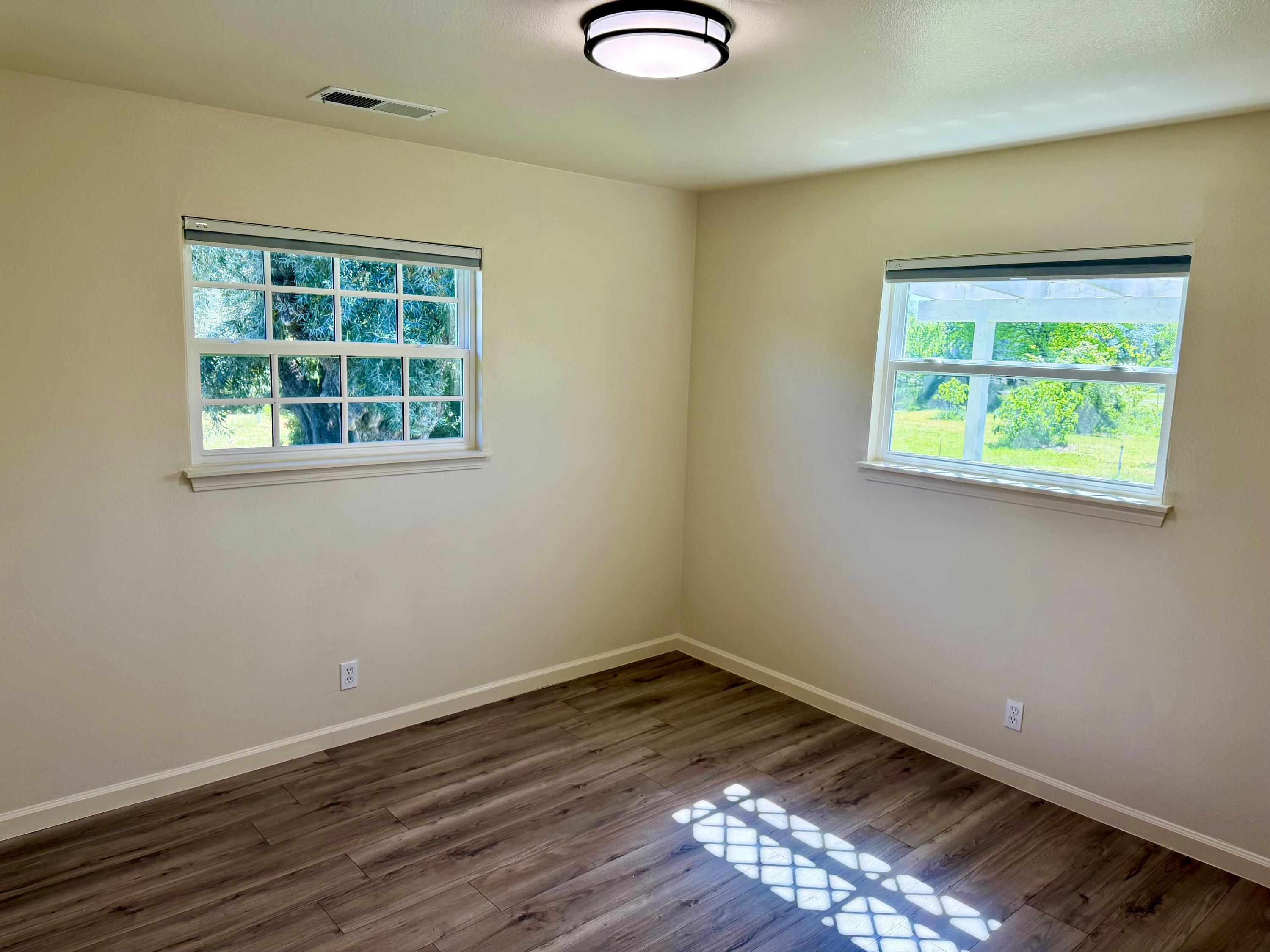 5572 Olive Street Anderson, CA 96007 - Photo 15 of 35 an empty room with wooden floor and windows