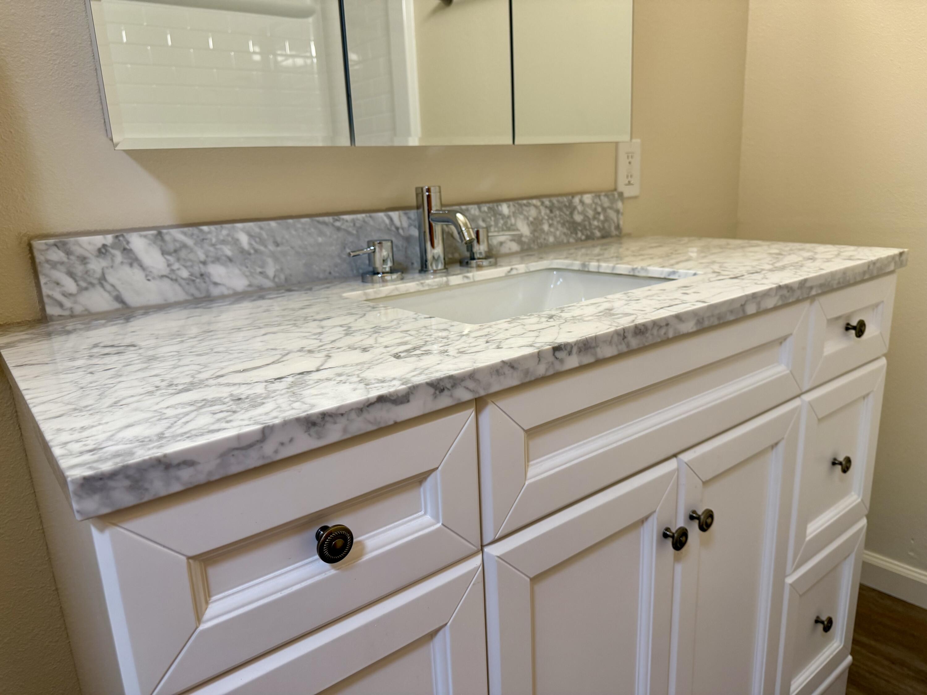 5572 Olive Street Anderson, CA 96007 - Photo 17 of 35 a bathroom with a granite countertop sink and white cabinets