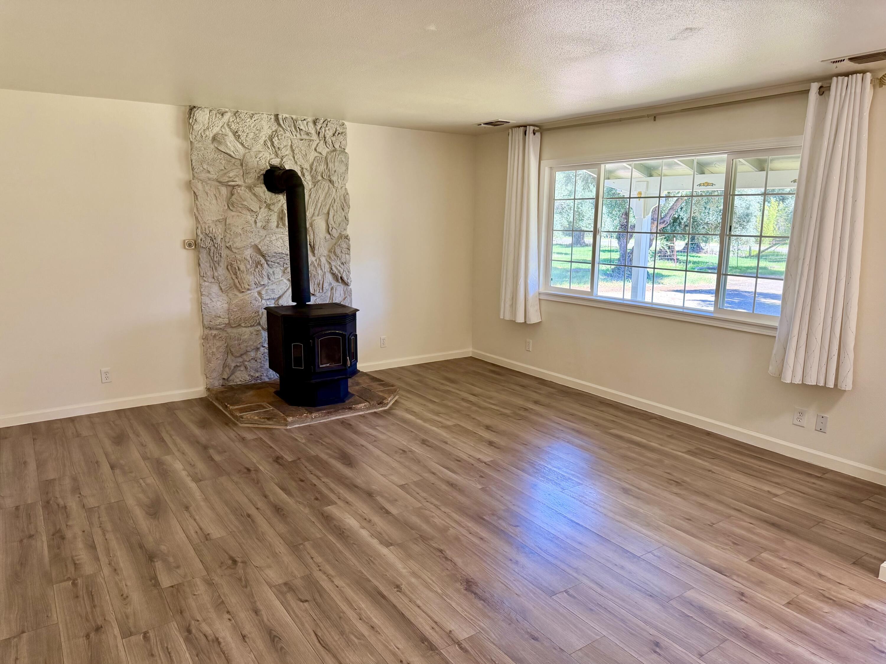 5572 Olive Street Anderson, CA 96007 - Photo 8 of 35 wooden floor in an empty room with a window