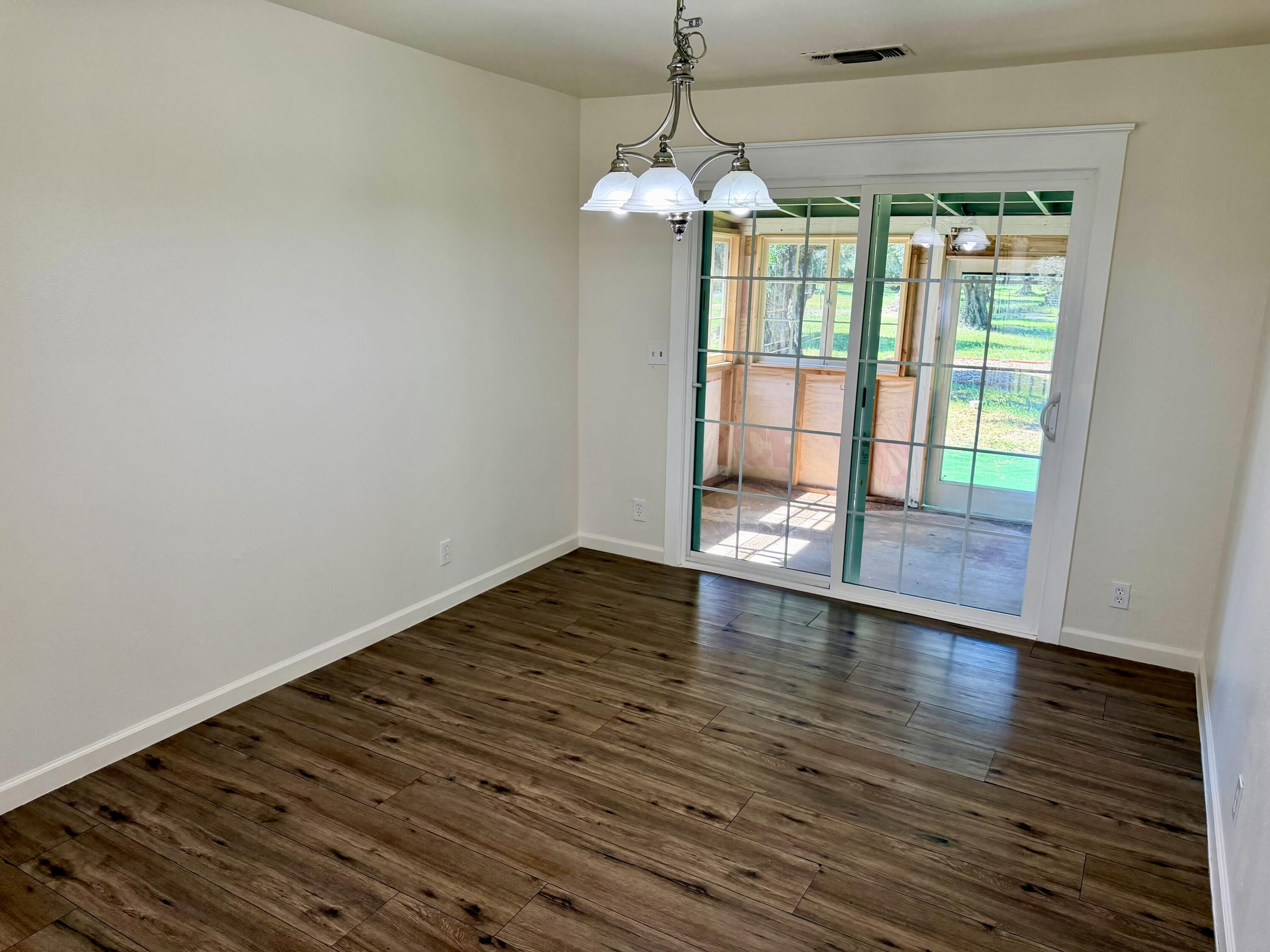 5572 Olive Street Anderson, CA 96007 - Photo 9 of 35 a view of an empty room with wooden floor and a window